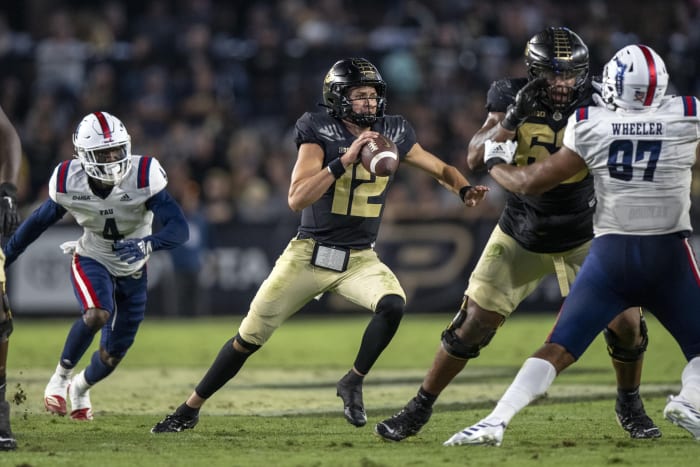Sep 24, 2022; West Lafayette, Indiana, USA; Purdue Boilermakers quarterback Austin Burton (12) scrambles away from Florida Atlantic Owls safety Teja Young (4) during the second half at Ross-Ade Stadium.